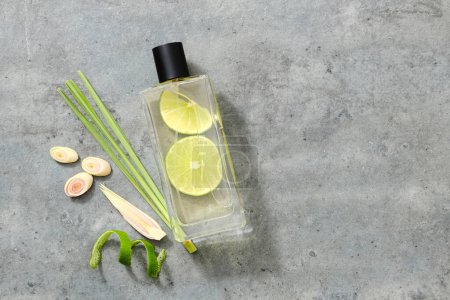 Mockup scene for product of lemon and lemongrass essential oils extract with glass bottle without label on gray background. Fresh lemongrass slices, lemon peel are decorate