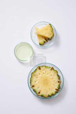 Photo for Fresh pineapple sliced, triangular pieces and essence in petri dishes on white background. Advertising photo for cosmetic of pineapple extract, rich in vitamin C for anti-oxidant - Royalty Free Image