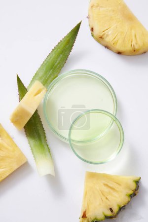 Frische Ananasscheiben und grüne Blätter auf weißem Hintergrund. Ananasessenz ist in Petrischalen enthalten. Ananas ist reich an antioxidativem Vitamin C und verlangsamt den Alterungsprozess.