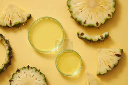 Photo for Top view of petri dishes containing yellow essence, fresh pineapple slices decorated on yellow background. Pineapple oil, serum with pineapple extract for natural facial skin care. - Royalty Free Image
