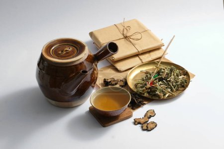 Decoction pot and medicine cup, medicine package and some dried herbs on light background. Herbal collection for the preparation of a tonic drink