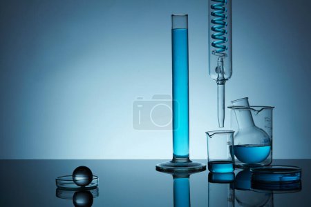 Photo for Front view of lab glassware containing blue solution in the right, on back lit background. Space for display product, text and design. Minimal concept. - Royalty Free Image