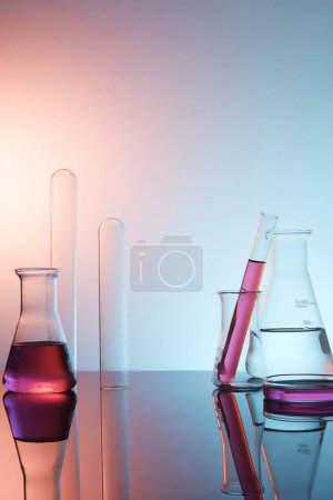 Photo for Science and medical background with lab glassware filled purple liquid on purple gradient background. Lab theme, front view, space for text and design. - Royalty Free Image