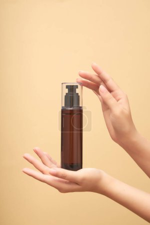 Photo for Mockup of cosmetics in the form of toner bottles or hair sprays cradled in women's hands on beige background. Advertising photo for cosmetic, space for design - Royalty Free Image