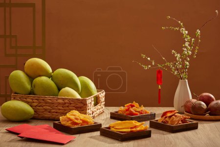 Téléchargez les photos : Vue de face des mangues, fruits de la passion et confiture de fruits sur table en bois. Ce sont des aliments traditionnels dans les vacances traditionnelles du Têt. Nouvel an lunaire. Décorations pour la célébration du Nouvel An chinois dans la chambre - en image libre de droit