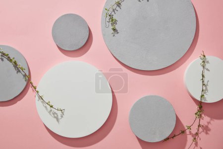 Photo for Top view of gray and white podiums and branches flower on pink background. Pedestal for cosmetic product and display presentation - Royalty Free Image