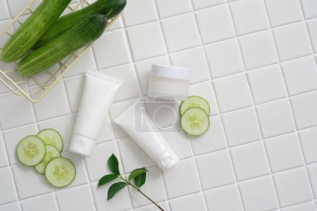 Photo for Empty label white tubes and jar decorated with a basket of Cucumber and Cucumber slices with green leaves. Beauty product extracted from Cucumber (Cucumis sativus) have anti-inflammatory properties - Royalty Free Image