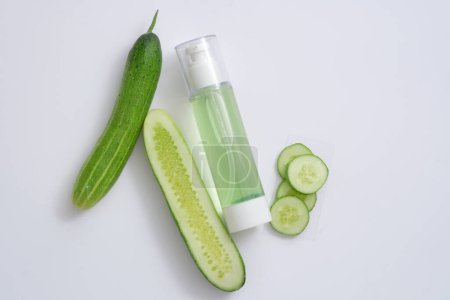 Photo for Pump bottle filled with liquid extracted from Cucumber decorated with Cucumber slices. Cucumber (Cucumis sativus) have the ability to reduce swelling and puffiness of the skin. - Royalty Free Image
