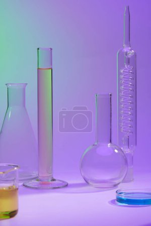 Blank space in the middle of several laboratory glassware containing fluid in many colors. Concept of science, production of cosmetics