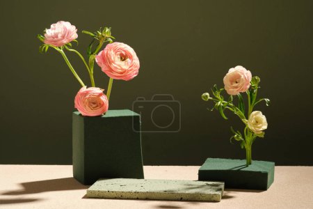 Photo for Beautiful Persian Buttercup flowers are arranged in block of floral foam. Empty space on the stone podium to display your product - Royalty Free Image