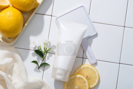 Ein Tablett mit Zitronen, Handtuch, Spiegel und einem Kosmetikbehälter sind arrangiert. Zitrone (Citrus limon) ist eine großartige Möglichkeit, Ihre Haut auf natürliche Weise zu reinigen und sie gesünder aussehen zu lassen