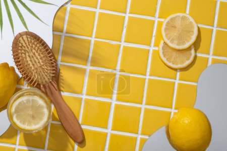 Cepillo de madera con espejos geométricos y rodajas de limón. El limón (Citrus limon) es rico en vitamina C que puede ayudar a blanquear la piel. Espacio en blanco para mostrar el producto de belleza extraído de Lemon