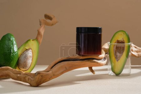 Photo for An empty label jar decorated with Avocado slices, contained inside a glass transparent beaker. Mockup for hair mask and face mask extracted from Avocado (Persea americana) - Royalty Free Image