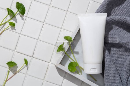 An unlabeled cosmetic container put on a tray with a towel. Product mockup. Gotu kola (Centella asiatica) brings more oxygen and nutrients to the skin