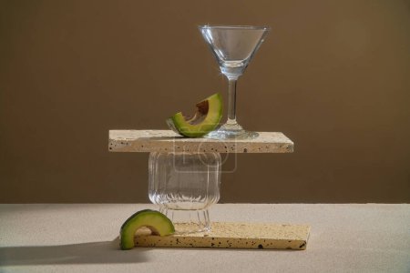 Photo for Rectangle podiums are stacked with glassware, decorated with Avocado slices. Blank space for product display. The antioxidants and vitamins in Avocado (Persea americana) oil can help heal dry skin - Royalty Free Image