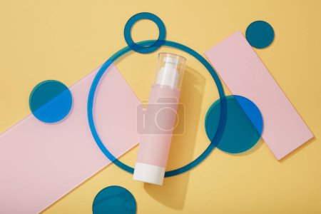 Photo for An unbranded pink pump bottle arranged with geometric shape acrylic sheets in blue and pink colors. Blank label for branding mock-up concept - Royalty Free Image