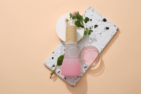 Photo for A stone podium with Lantana camara flowers, gradient jar and a glass petri dish filled with pink liquid placed on. Organic cosmetics packaging mockup - Royalty Free Image