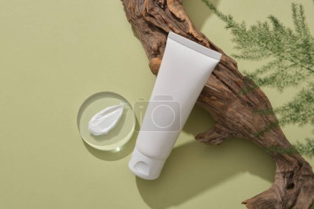 Photo for Cosmetic container without label is leaning on a big tree branch, a round transparent with cream texture and leaves arranged. Beauty product mockup - Royalty Free Image