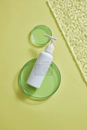 Photo for Minimal scene with an empty label white pump bottle dispenser decorated with two petri dishes containing green liquid. Beauty and body care product concept - Royalty Free Image