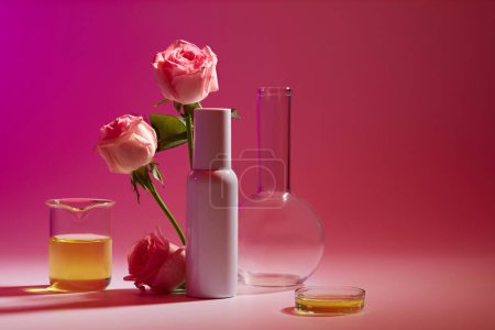 Photo for Front view in the laboratory with an empty label bottle decorated with Rose branches and some glassware. Copy space. The concept of beauty care products - Royalty Free Image