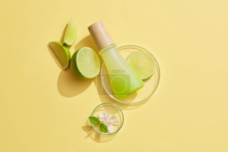 Unlabeled gradient jar with wooden cap placed on a glass petri dish with Lime slice over a pastel background. Mockup for beauty products of Lime (Citrus aurantiifolia) extract