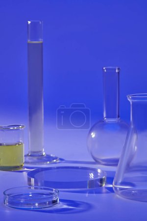 Over a blue background, several laboratory glassware are displayed with a transparent podium. Stage showcase on pedestal