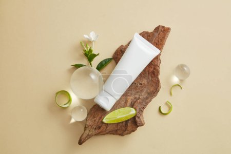 Photo for An empty label tube placed on tree branch, decorated with glass balls, flower, Lime slice and peel. Cosmetic product of Lime (Citrus aurantiifolia) extract can help brighten and lighten your skin - Royalty Free Image