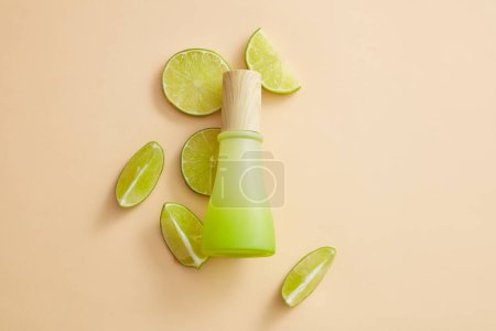 Some Lime slices are arranged with a blank label jar with wooden cap against pastel background. Lime (Citrus aurantiifolia) essential oil can slow down the physical effects of aging