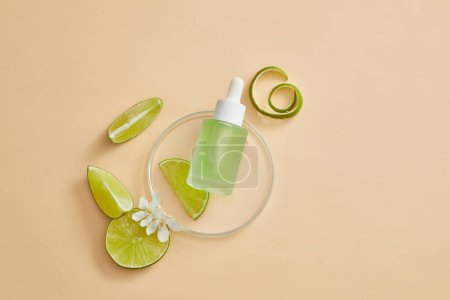 Photo for A round transparent podium with a glass bottle containing green fluid with dropper placed on with several Lime slices. Beauty product with Lime (Citrus aurantiifolia) extract - Royalty Free Image