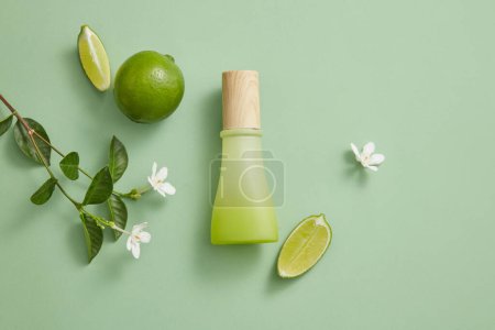 Photo for Flower branches arranged with an unlabeled gradient green and white jar. Concept for natural, organic beauty products extracted from Lime (Citrus aurantiifolia). Cosmetic product advertising - Royalty Free Image