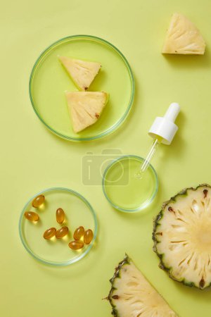 Glass petri dish filled with essence extracted from pineapple and few vitamin medicines, a dropper displayed. Pineapple (Ananas comosus) is rich in bromelain and vitamin C