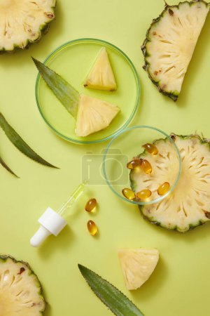 Some yellow medicines decorated with a dropper and a petri dish of essence liquid and pineapple slices. Pineapple (Ananas comosus) helps improve glowing skin and healthy hair