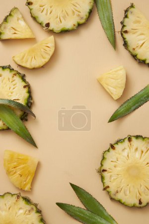 Many pineapple slices and leaves decorated in a circle with a blank space in the middle for cosmetic product presentation. Pineapple (Ananas comosus) helps your skin more rejuvenated complexion