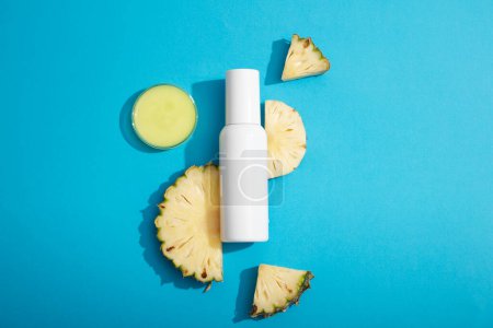 A petri dish of essence extracted from pineapple displayed with a white bottle. Branding mockup with empty label. Pineapple (Ananas comosus) contains antioxidants can treat skin damaged by sunburn