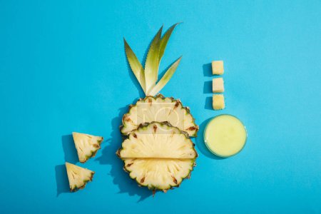 Photo for Pineapple slices and leaves are arranged on light blue background with a glass petri dish of essence extracted from pineapple (Ananas comosus). Concept for natural, organic beauty products. - Royalty Free Image