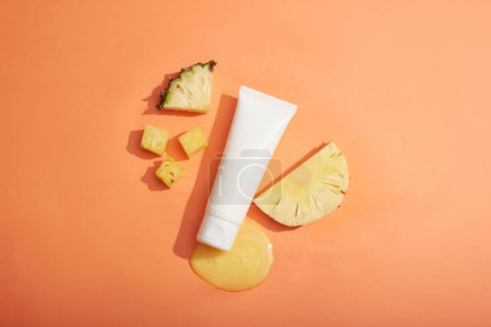 Pineapple slices and essence extracted from pineapple displayed with a white tube. Organic beauty product concept. Pineapple (Ananas comosus) is used in production of cosmetic as ingredient