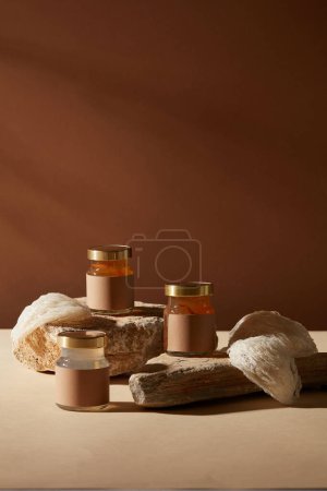 Photo for Some edible bird nests and bird nest soup contained in glass transparent jars placed on stones with dark background. Bird nest brings advantages for many age groups - Royalty Free Image