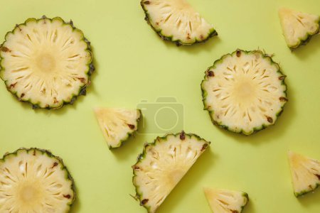 Photo for Against a pastel green background, some pineapple slices and half slices are decorated. Natural facial skincare ingredient - Royalty Free Image