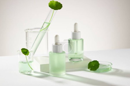 One of empty label bottles standing on a white podium, decorated with laboratory glassware. Photography science content. Branding mockup product based on Gotu kola (Centella asiatica)