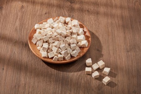 Photo for Poria cocos cut into cubes and placed on a wooden dish. Poria cocos (Wolfiporia extensa) has many benefits for health and contains antioxidants that prevent skin aging, help smooth skin, whiten skin - Royalty Free Image