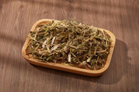 Photo for Chinese motherwort (Leonurus japonicus) with dish decorated on wooden table. It reduced risk of heart disease, as well as decreased blood pressure and heart rate caused by stress or anxiety - Royalty Free Image