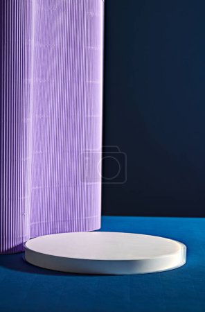 Téléchargez les photos : Un podium blanc vide en forme ronde décoré de papier violet clair sur fond sombre. Scène vide minimale de présentation de produits cosmétiques - en image libre de droit