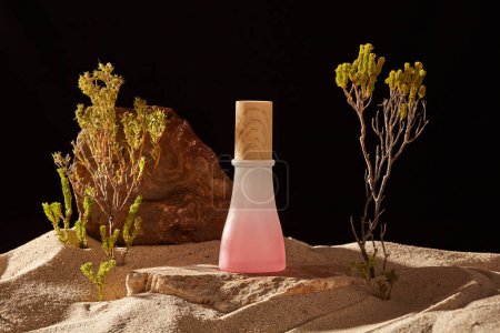 A block of stone with a gradient pink color jar standing on, displayed with the sand and small trees. Beauty product mockup with empty label