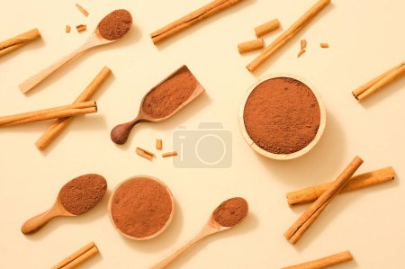 Foto de Vista superior de canela (Cinnamomum) en polvo colocado en cucharas de madera y cuencos con varios palos de canela. Se puede utilizar para cocinar y también como hierbas buenas para la salud - Imagen libre de derechos