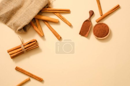Photo for A gunny bag containing cinnamon stick decorated with cinnamon powder on minimalist background. Powder and essential oil extracted from Cinnamon (Cinnamomum) is good for health and skin - Royalty Free Image