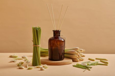A glass jar containing essential oil extracted from lemongrass (Cymbopogon citratus) with reed diffusers, use to scent the room and assistance people to relax
