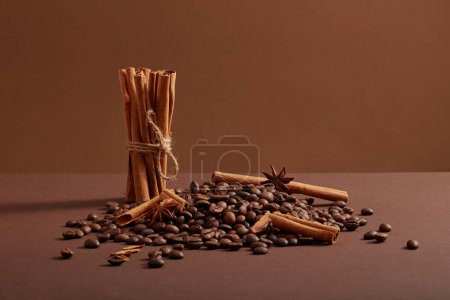 Téléchargez les photos : Une pile de grains de café avec de l'anis étoilé et des bâtons de cannelle décorés sur un fond minimaliste. Herbacées pour améliorer l'état de santé ou les soins de la peau - en image libre de droit