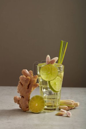 Téléchargez les photos : Un verre de limonade mélangé avec du gingembre et de la citronnelle, décoré d'une tranche de citron, de citronnelle et de gingembre. Ce type de boisson est bon pour la santé - en image libre de droit