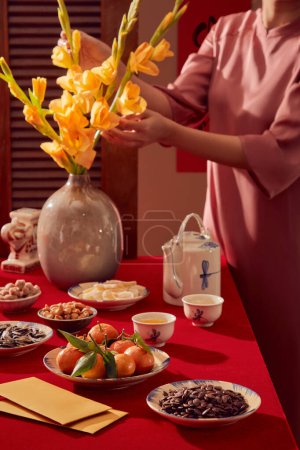 Foto de Una mesa de temática roja para la celebración del Año Nuevo Lunar. Mandarinas, muchos tipos de nueces, sobres amarillos sobre la mesa - Imagen libre de derechos