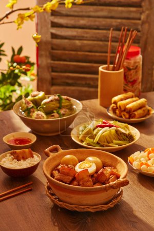 Foto de Comida tradicional vietnamita con sopa de melón amargo relleno de cerdo, rollos de primavera y cerdo caramelizado y huevos - Imagen libre de derechos